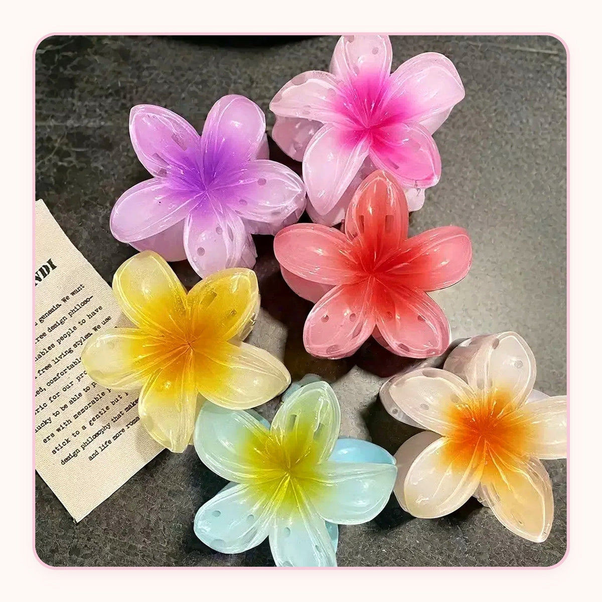 Six translucent plumeria flower claw clips in pastel colors