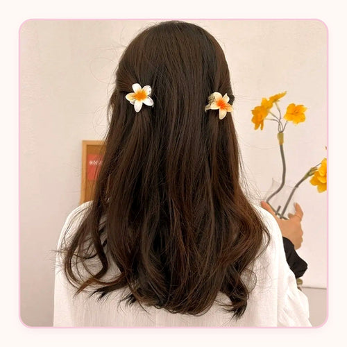 Six translucent plumeria flower claw clips in pastel colors