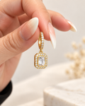 Gold huggie earring with clear emerald-cut crystal drop, close-up lifestyle view