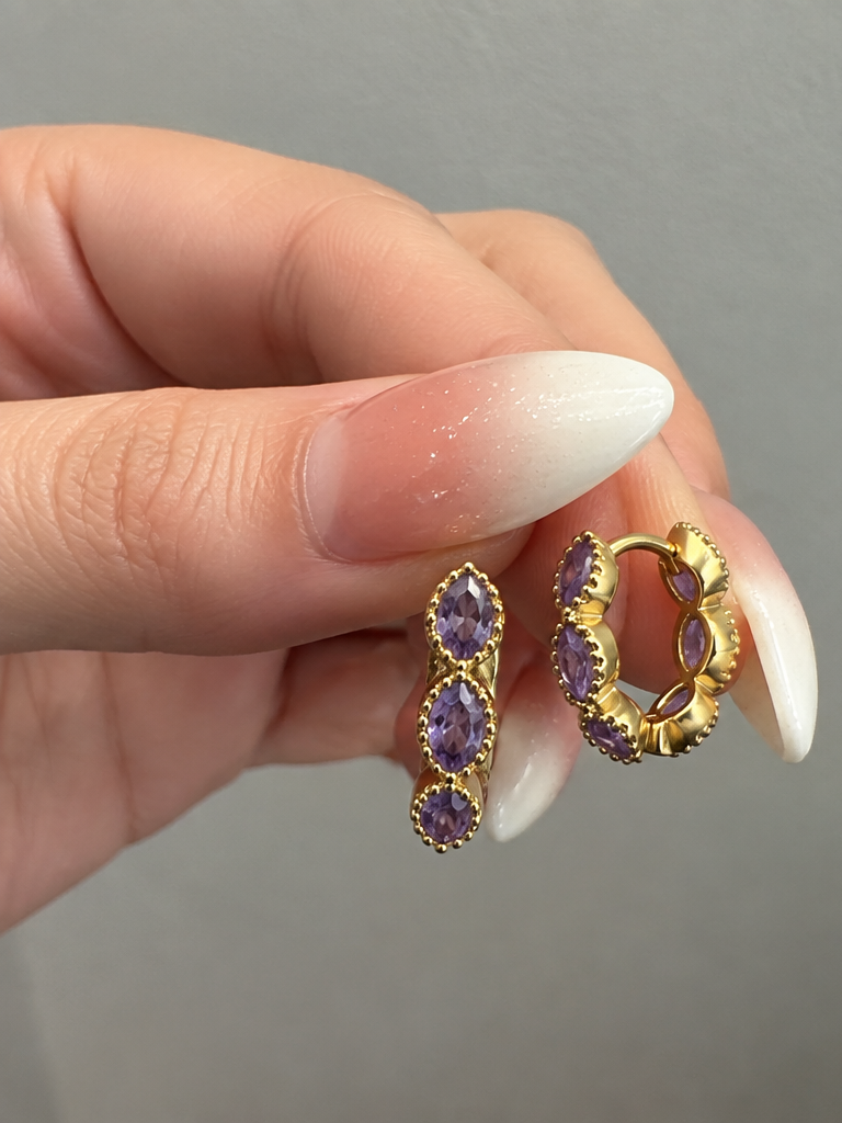 Gold hoop earring with three purple stones